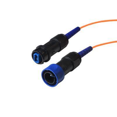 Zwei verbundene Glasfaserkabel mit blauen und schwarzen Anschlüssen auf einem orangefarbenen Kabel.