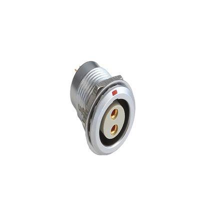 Eine Metall-Elektrosteckdose mit zwei goldenen Kontaktpunkten und einem verschraubbaren Außengehäuse, zur Befestigung an Instrumententafeln oder Paneelen konzipiert.