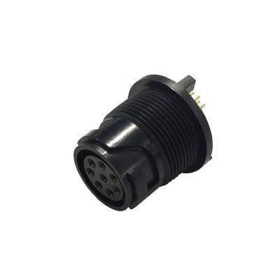 Ein schwarzer kreisförmiger Stecker mit mehreren Anschlüssen, entwickelt für elektronische Geräteverbindungen, von einer schrägen Seitenansicht vor einem einfarbigen Hintergrund gezeigt.