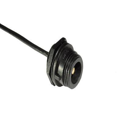 Eine schwarze runde Steckdose mit einem einzelnen Anschluss, an ein Kabel angeschlossen, vor einem weißen Hintergrund.