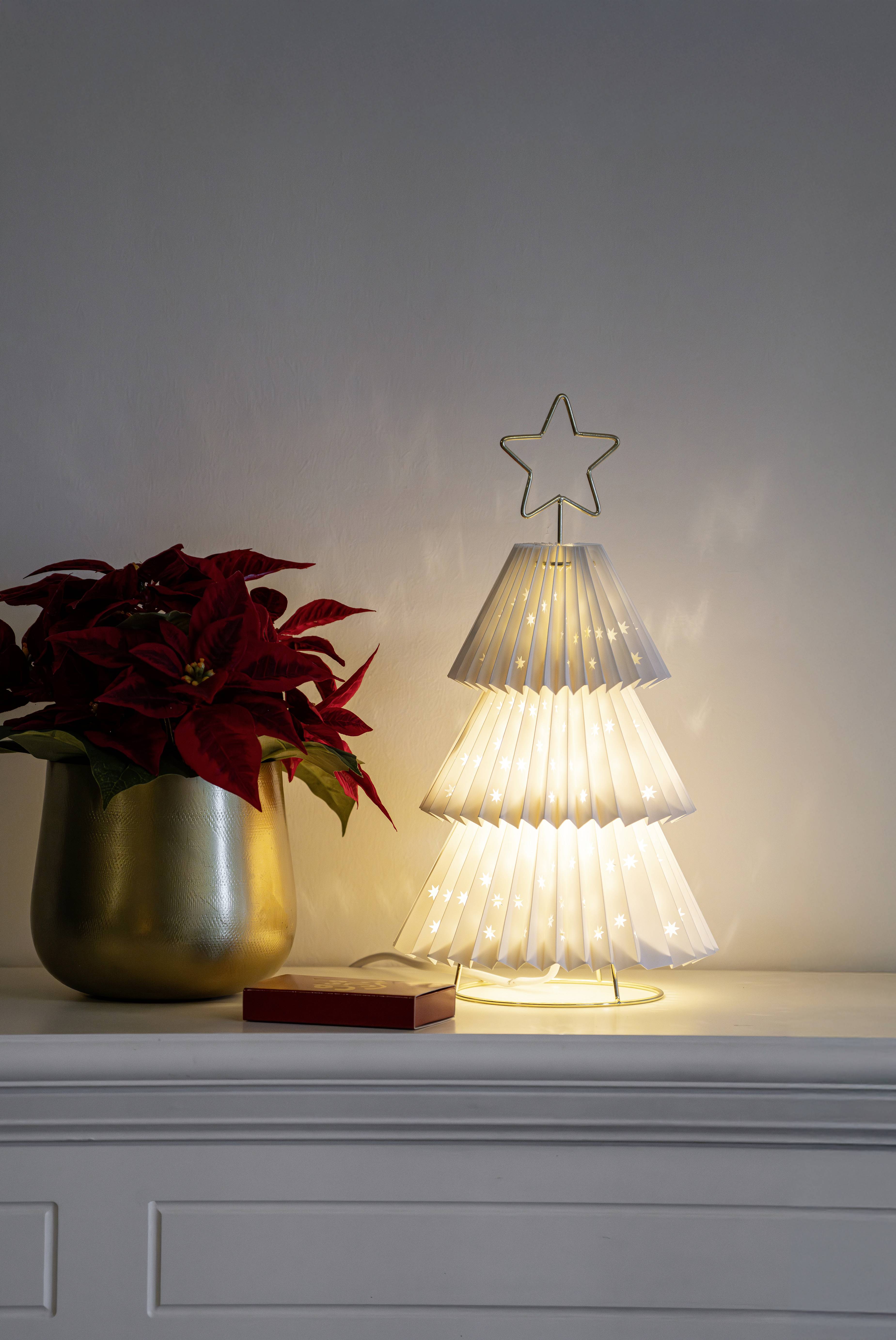 Eine leuchtende Weihnachtsbaumlampe aus Papier mit einem Stern an der Spitze steht auf einem weißen Regal neben einer roten Weihnachtsstern in einem goldenen Topf.