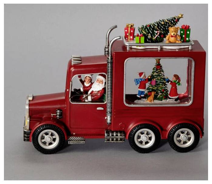 Ein roter Spielzeug-Truck mit dem Weihnachtsmann am Steuer und einer festlichen Weihnachtsszene mit einem Baum und Geschenken, die im Fenster des Anhängers zu sehen sind.