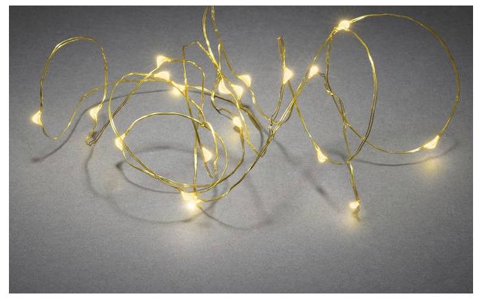 Eine Reihe von warmweißen LED-Lichterketten ist kunstvoll in einem Spiralmuster auf einer grauen Oberfläche angeordnet.