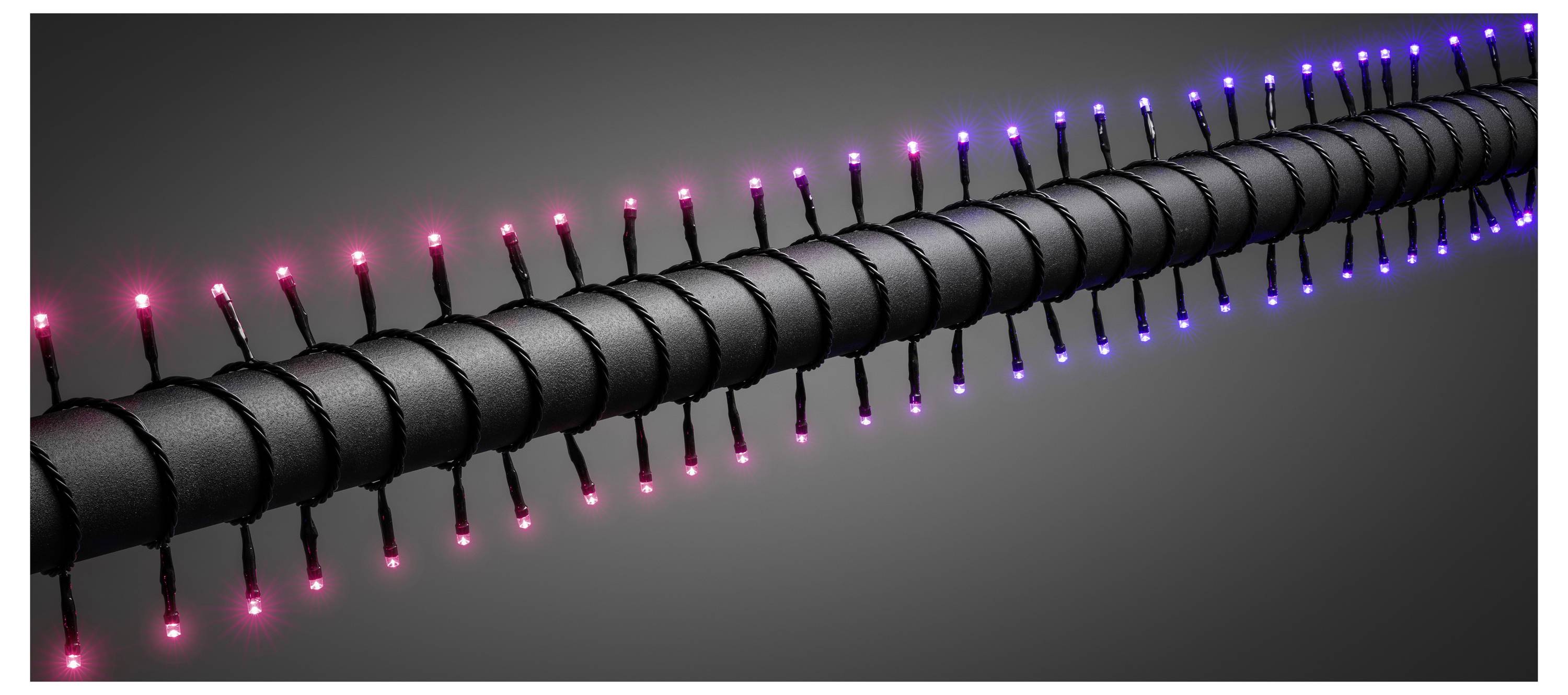 Ein langer, zylindrischer Gegenstand mit rot und blauen LED-Leuchten, die gleichmäßig entlang seiner Oberfläche verteilt sind, vor einem dunklen Hintergrund.