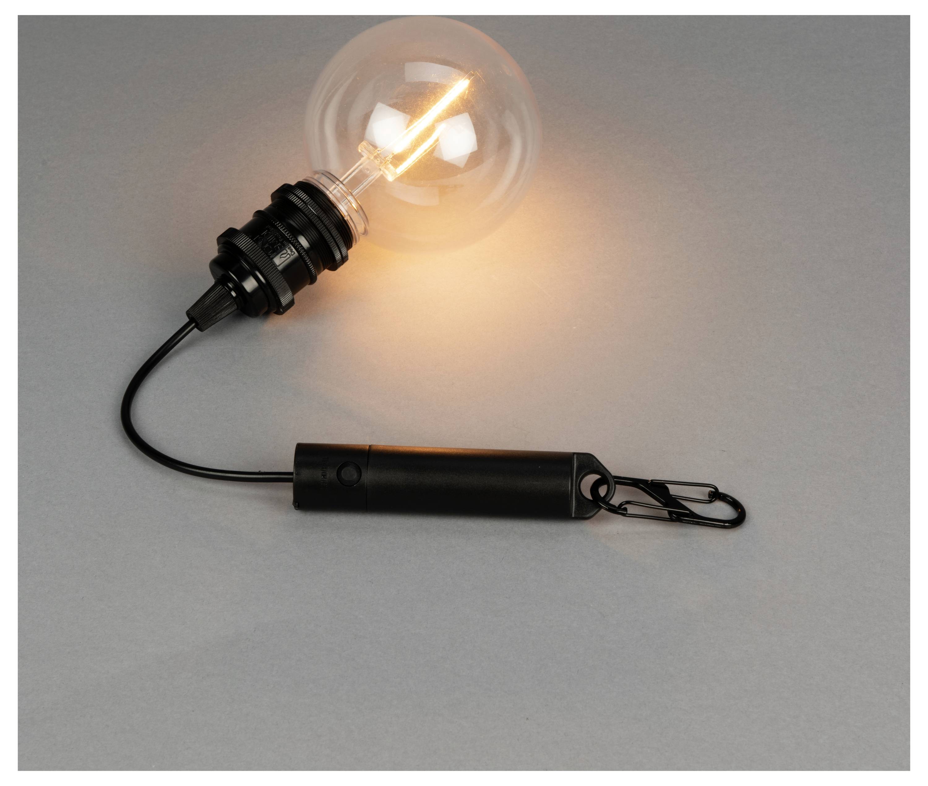 Eine leuchtende Birne, die an einem schwarzen zylindrischen Griff mit einem Draht und einer Klemme befestigt ist und auf einer neutralen Oberfläche ruht.