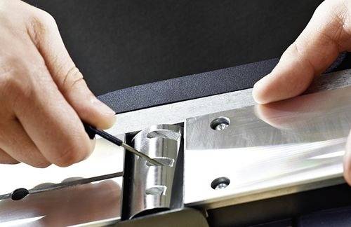 Hände, die ein Dietrich-Werkzeug benutzen, um einen Metallverschlussmechanismus zu manipulieren.