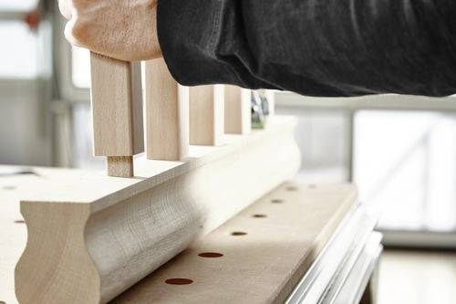 Eine Person montiert Holzverbindungen auf einer Werkbank und demonstriert Handwerkskunst und Holzbearbeitungstechniken.