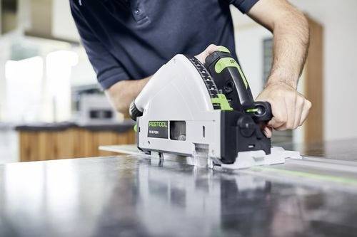 Eine Person verwendet eine Festool Kreissäge, um auf einer Metalloberfläche in einer Werkstatt eine gerade Linie zu schneiden und dabei Präzision und Kontrolle in den Mittelpunkt stellt.