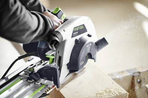 Eine Person verwendet eine Kreissäge, um ein Stück Holz zu sägen, wobei Sägespäne durch die Luft fliegen. Die Säge ist mit der Marke 'Festool HK 55' gekennzeichnet.