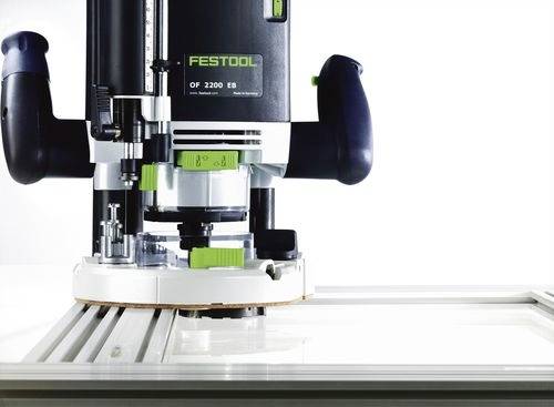 Eine Festool OF 2200 EB Handoberfräse auf einer flachen Oberfläche, die ihre robuste Bauweise und präzise Komponenten zeigt, die für professionelle Holzbearbeitung entwickelt wurden.