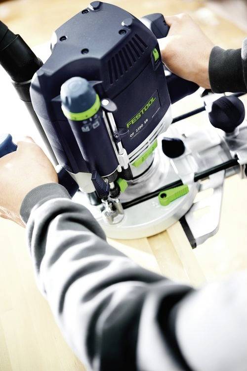 Eine Person verwendet einen Festool-Router auf einer Holzoberfläche und konzentriert sich dabei auf präzises Holzarbeiten.