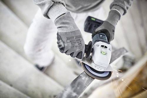 Eine Person mit Handschuhen benutzt eine Winkelschleifer auf einer Metalloberfläche, wobei Funken sprühen. Sie arbeitet sorgfältig an einem Treppenaufgang.