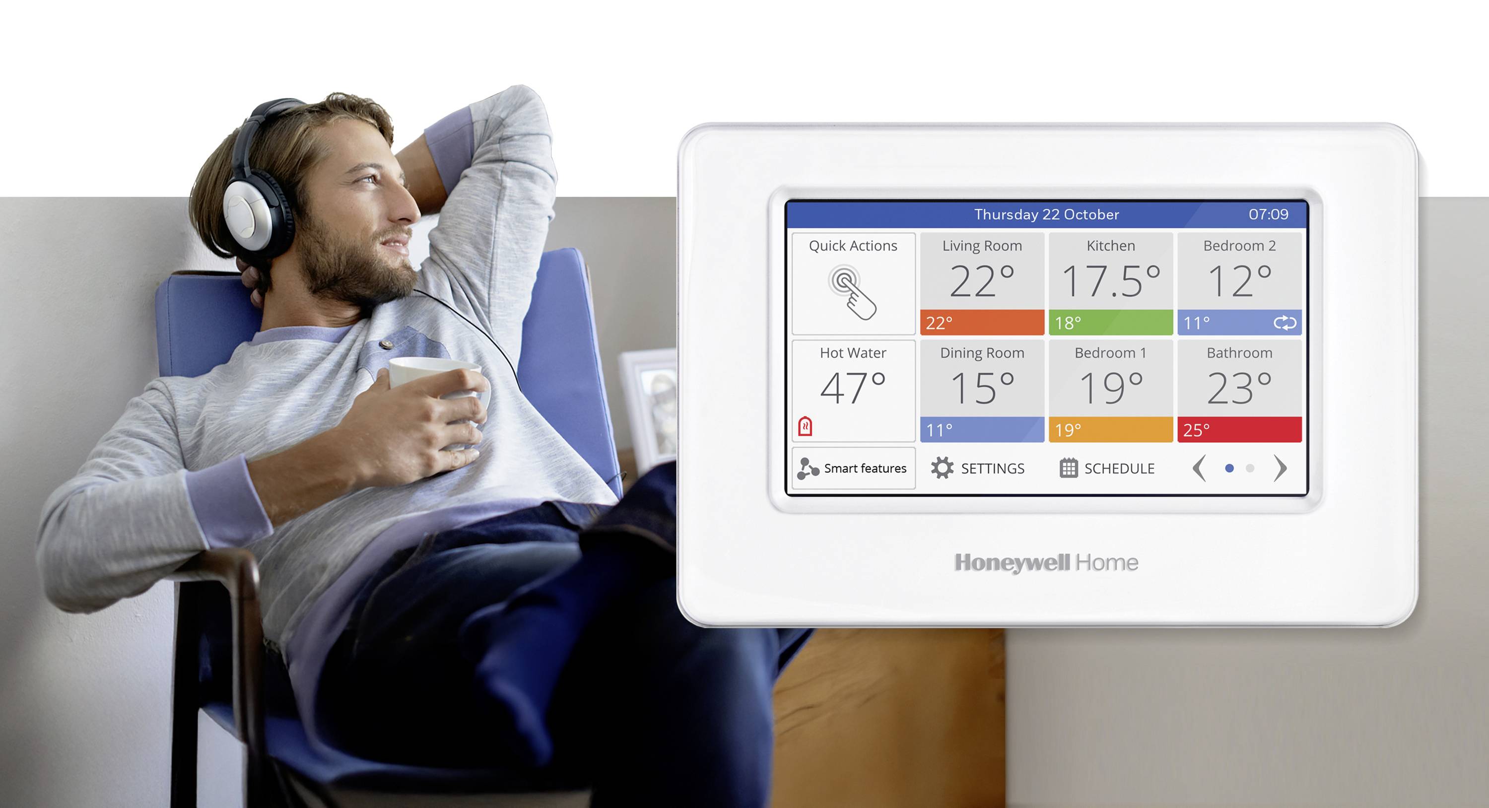 Ein Mann entspannt sich mit Kopfhörern und einem Getränk neben einem Honeywell Home Thermostat, auf dessen Bildschirm Raumtemperaturen und Steuerungselemente angezeigt werden.