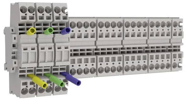 Elektrische Klemmenleiste mit mehreren Anschlussports, versehen mit gelben, grünen und blauen Kabeln, verwendet zur Kabelführung.