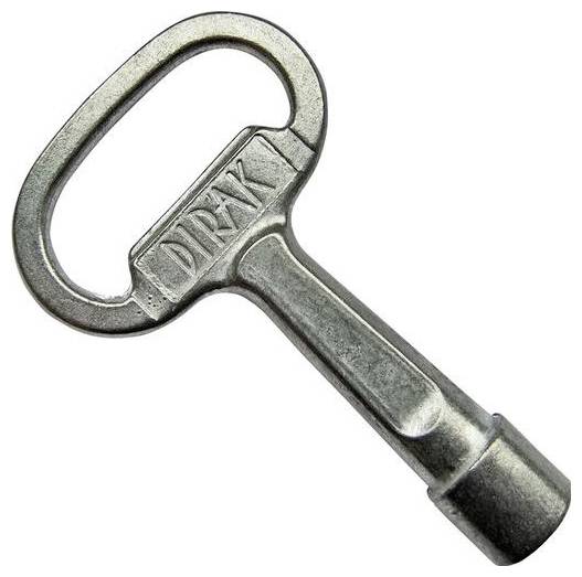 Silberner Metallschlüssel mit einem ovalen Griff und dem Wort 'DIRAK', das eingraviert ist. Der Schlüssel hat eine einzigartige fassförmige Spitze.