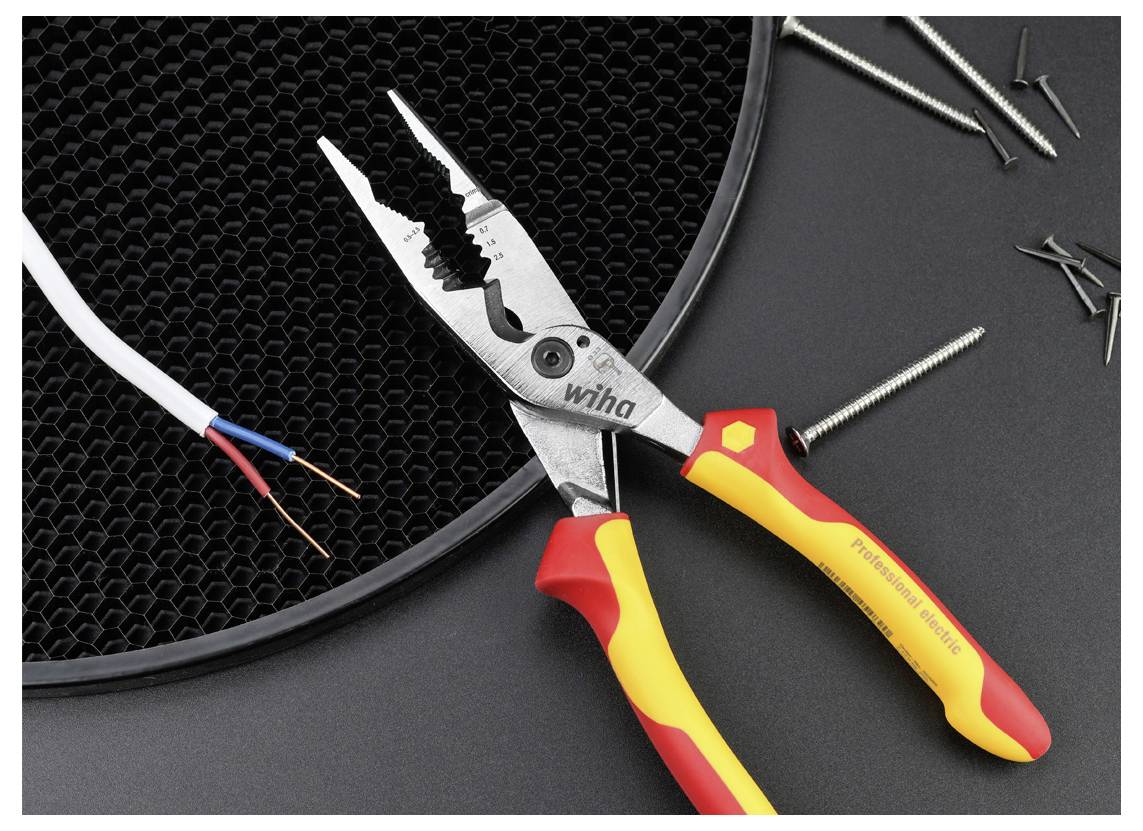 Ein Paar Zangen mit roten und gelben Griffen neben freigelegten Drahtenden, Schrauben und einem schwarzen Gitter auf einer dunklen Oberfläche.