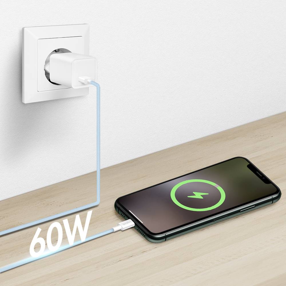 Ein Smartphone lädt auf einer Holzoberfläche mit einem Kabel, das an eine Wandsteckdose angeschlossen ist. Der Bildschirm zeigt ein grünes Ladessymbol, und das Kabel ist mit '60W' beschriftet.