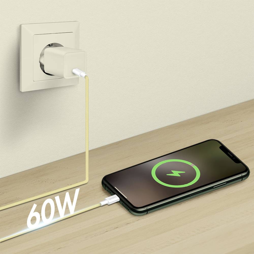 Ein Smartphone auf einer Holzoberfläche wird über einen 60-W-Ladestecker, der mit einer Wandsteckdose verbunden ist, aufgeladen, wobei auf dem Bildschirm das Ladessymbol zu sehen ist.