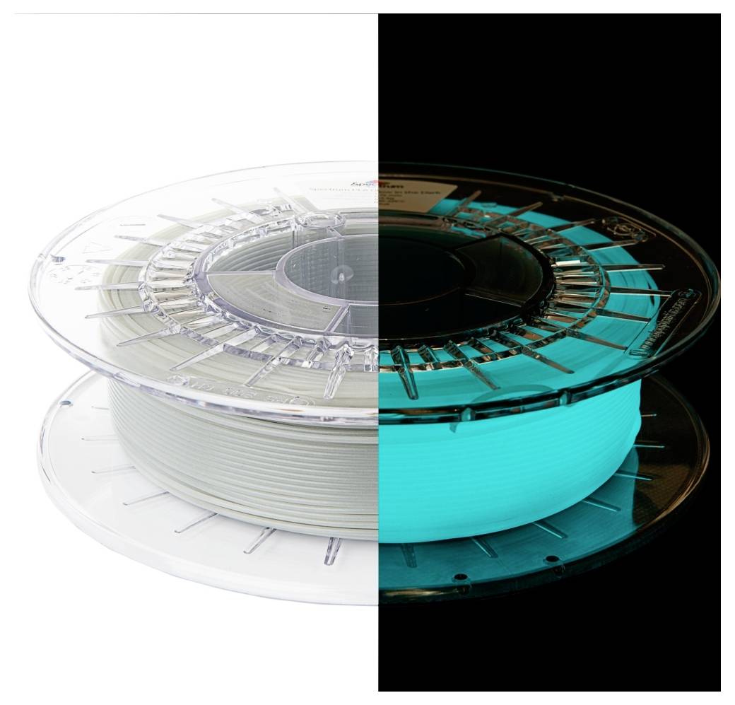 Eine Spule, die einen Filament zeigt, der zur Hälfte bei Tageslicht weiß erscheint und zur Hälfte im Dunkeln blau leuchtet, was den Glow-in-the-Dark-Effekt veranschaulicht.
