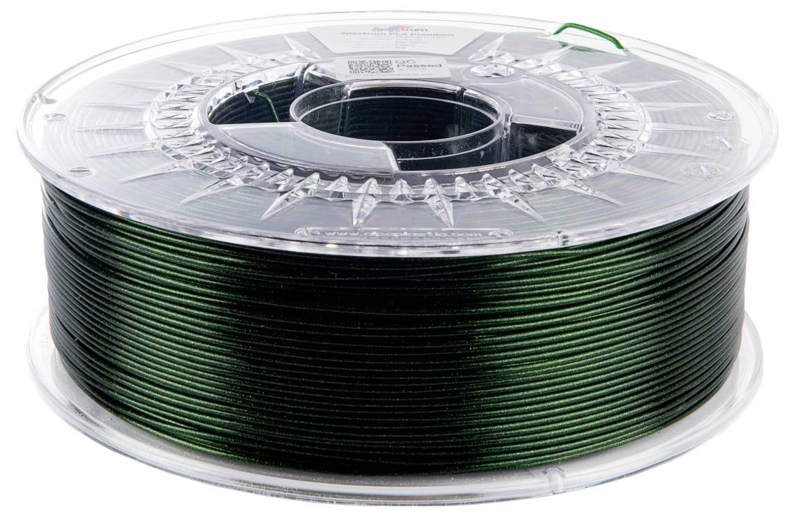 Eine Spule dunklen grünen Filamentes zum 3D-Druck, ordentlich aufgewickelt, mit einer durchsichtigen Plastikabdeckung.