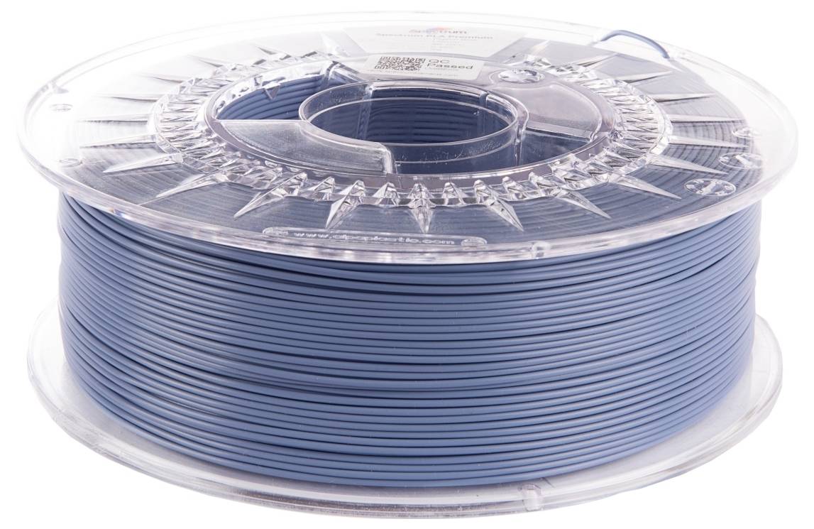 Eine Spule blauen Filaments für den 3D-Druck, sauber aufgewickelt und in einer transparenten Plastikbox eingeschlossen, vor einem weißen Hintergrund platziert.