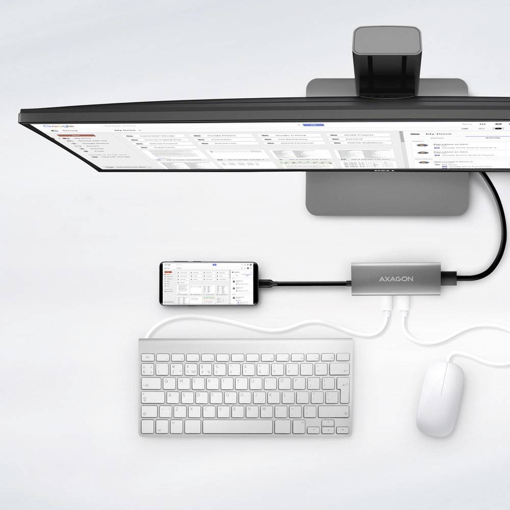 Ein Monitor, der Tabellenkalkulationen anzeigt, ist mit einem Smartphone verbunden, das über einen Hub mit der Bezeichnung 'AXAGON' mit einer Tastatur und einer Maus verknüpft ist.