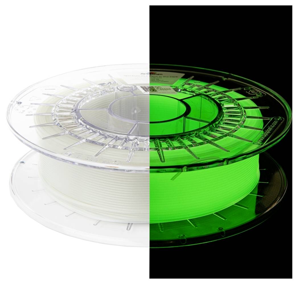 Die Hälfte einer 3D-Drucker-Filamentspule leuchtet im Dunkeln grün, während die andere Hälfte bei Licht weiß erscheint.