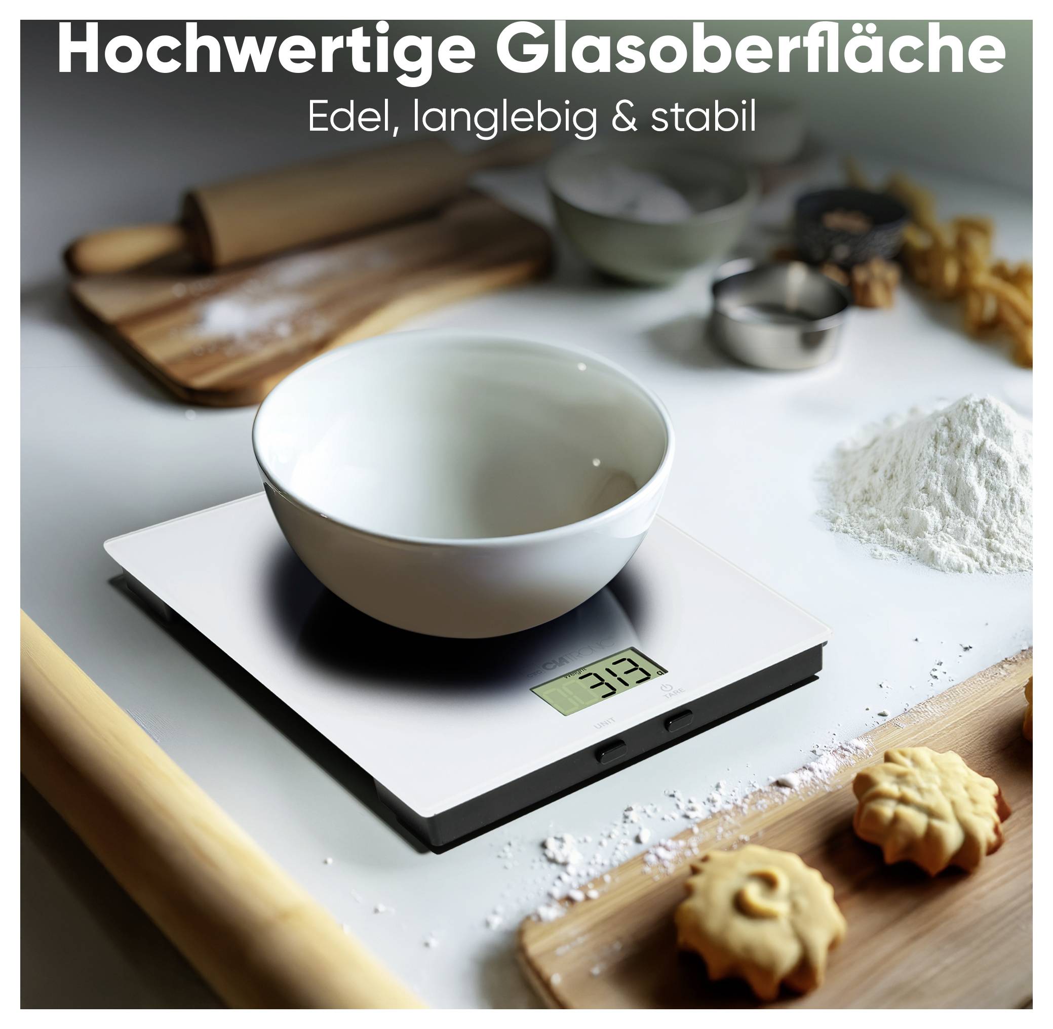 Eine digitale Küchenwaage mit einer Schüssel, die 33 Gramm anzeigt, umgeben von Backzutaten und -utensilien. Text lautet: 