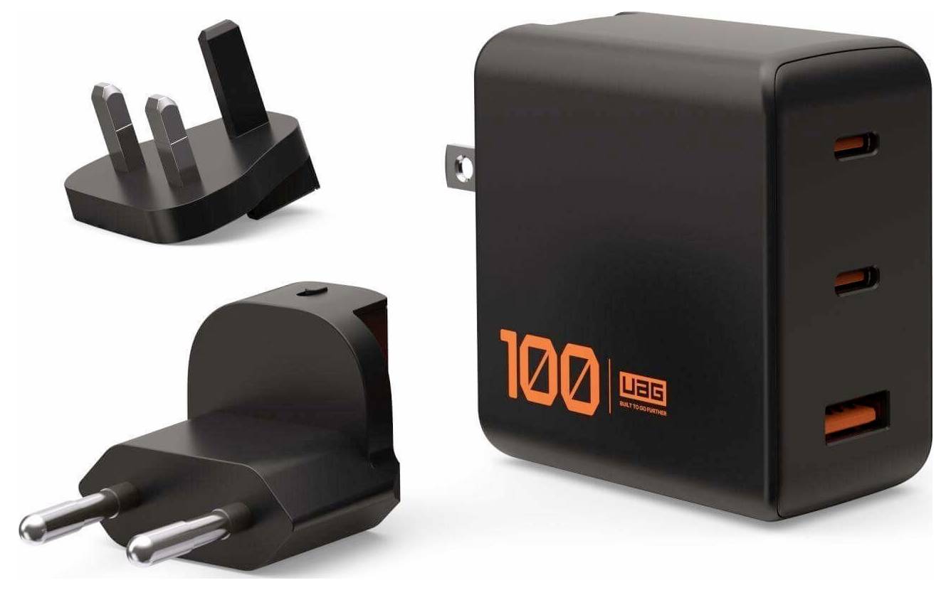 Ein schwarzer Multi-Port-USB-Wandladegerät mit drei internationalen Steckeradaptern, mit orangefarbener Aufschrift '100' und 'uag' auf dem Ladegerät.