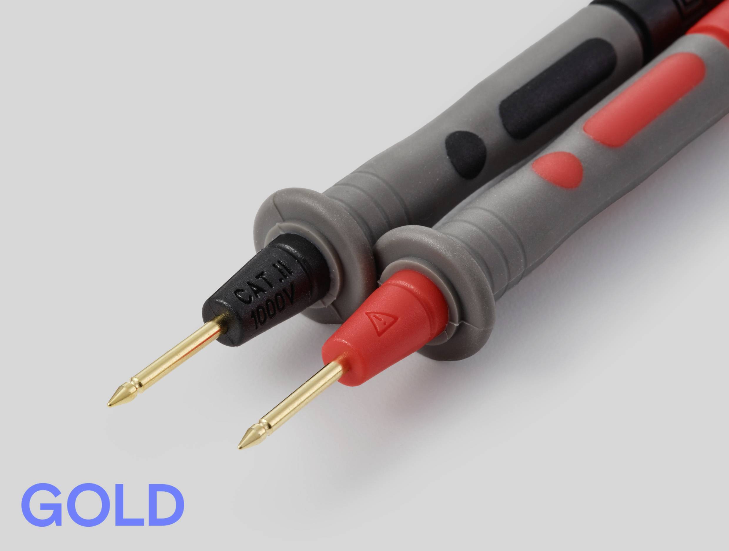 Zwei Elektronik-Prüfspitzen aus der Nähe, eine schwarz und eine rot, mit goldenen Spitzen. Der Text 'GOLD' ist in fetter blauer Schrift unten links.