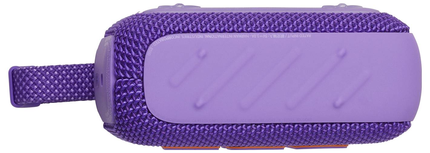 Ein lila tragbarer Bluetooth-Lautsprecher mit einem strukturierten Stoffbezug und einer Schlaufe zum einfachen Tragen wird in horizontaler Ansicht gezeigt.