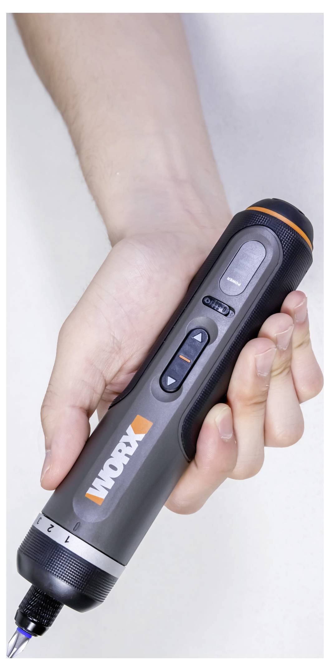 Eine Hand hält ein kompaktes, graues elektrisches Werkzeug mit der Aufschrift 