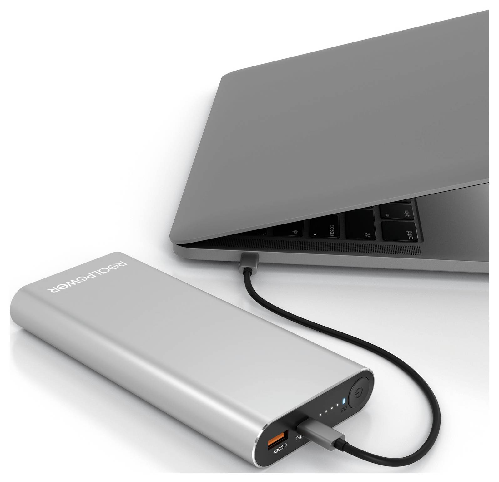 Ein silberner Powerbank, der über ein schwarzes Kabel mit einem geschlossenen Laptop verbunden ist und Ladestatus-Anzeigen auf dem Powerbank zeigt.