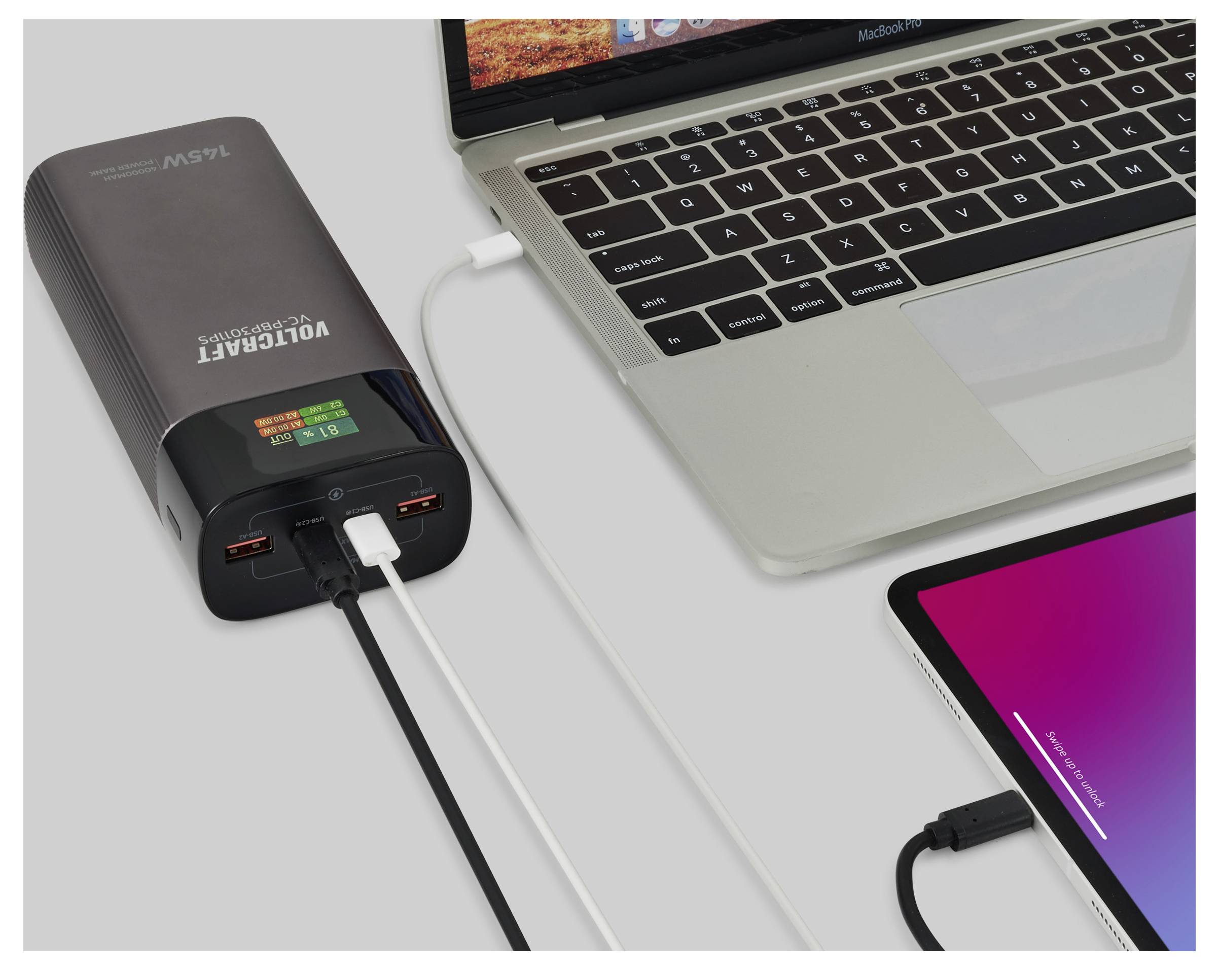 Ein Laptop und ein Tablet laden, verbunden mit einem Powerbank mit der Aufschrift 