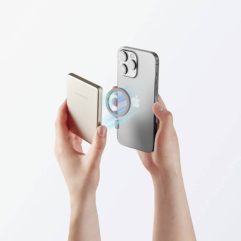 Hände, die ein silbernes Smartphone und eine beige Powerbank halten und sie für das drahtlose Aufladen ausrichten, wobei eine sichtbare Ladeanimation zu sehen ist.