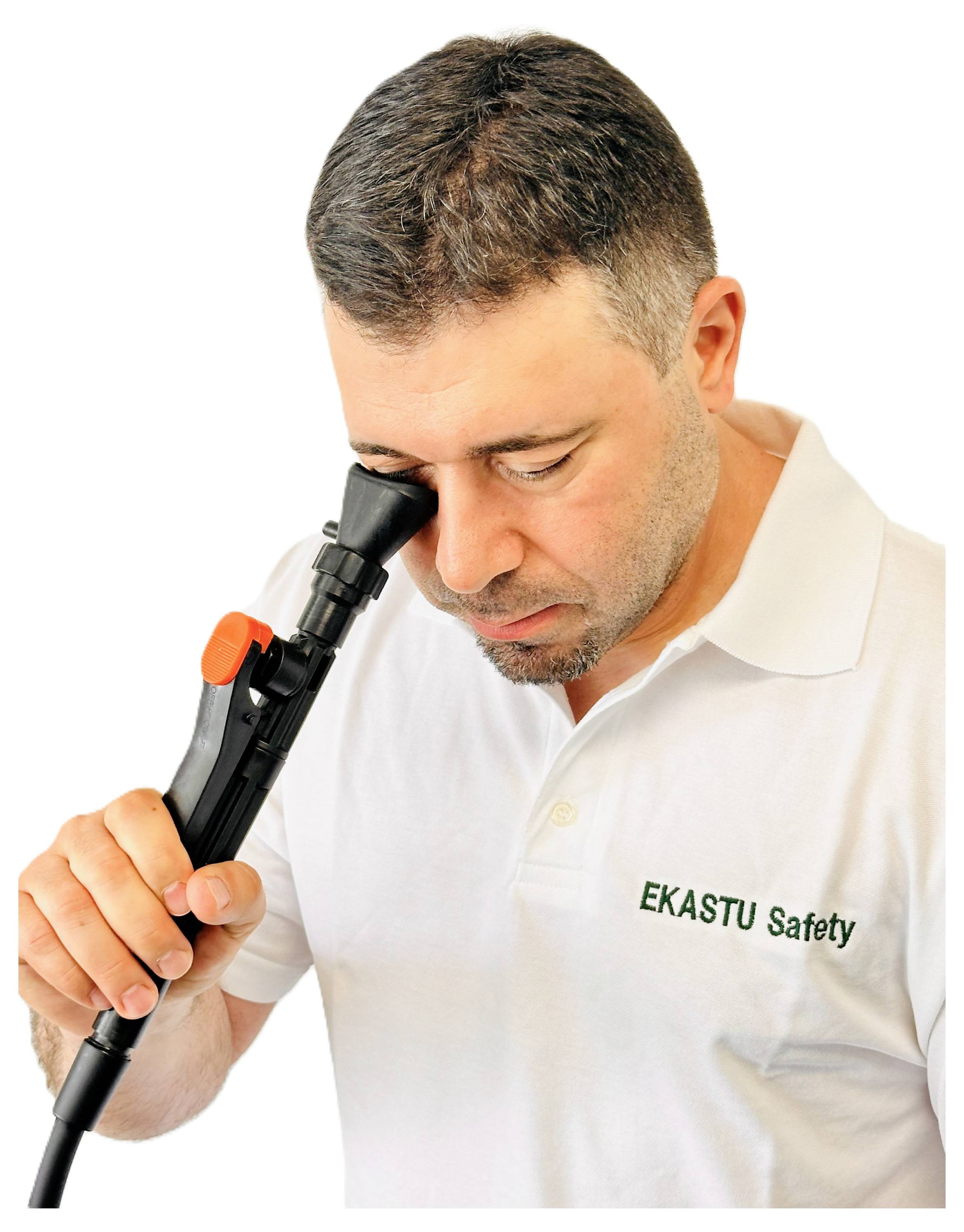 Ein Mann in einem weißen 'EKASTU Safety' Shirt schaut durch ein schwarzes Okular eines Geräts und konzentriert sich aufmerksam.