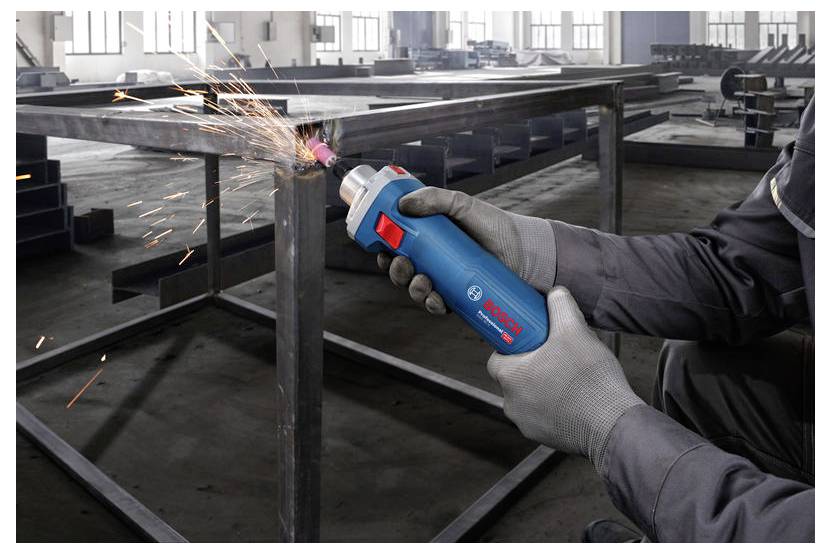 Eine Person mit Handschuhen verwendet ein Bosch-Werkzeug, um einen Metallrahmen in einer industriellen Werkstatt zu schleifen, wobei Funken entstehen.