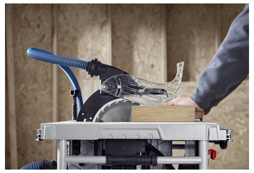 Eine Person verwendet eine Kreissäge in einer Werkstatt, um ein Holzbrett zu schneiden, wobei ein Sicherheitsschutz über der Sägeblatt angebracht ist.