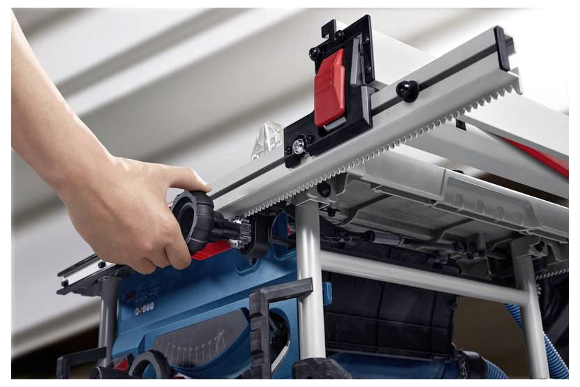 Eine Hand justiert den Drehknopf an einem Elektrowerkzeug mit sichtbaren Zahnrädern und einem roten Knopf, was die Einstellung oder Wartung des Werkzeugs veranschaulicht.