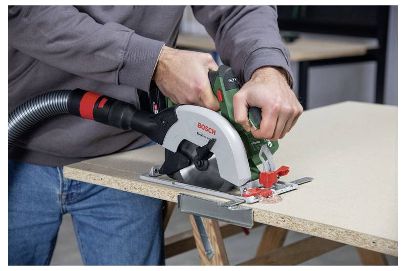 Eine Person verwendet eine Kreissäge, um ein Stück Holz auf einer Werkbank zu sägen und dabei einen Holzbearbeitungsprozess zu demonstrieren.