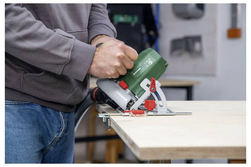 Eine Person verwendet eine Kreissäge, um ein Holzbrett in einer Werkstatt zu schneiden und damit ein laufendes Heim- oder Holzbearbeitungsprojekt zu demonstrieren.