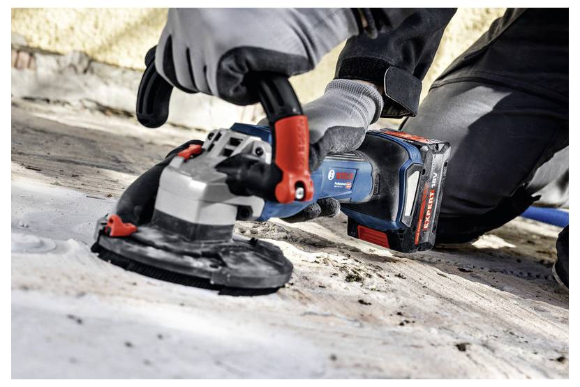 Eine Person, die ein tragbares Elektrowerkzeug verwendet, um eine Betonoberfläche zu schleifen, trägt dabei Schutzhandschuhe. Das Werkzeug ist blau und schwarz mit roten Akzenten.