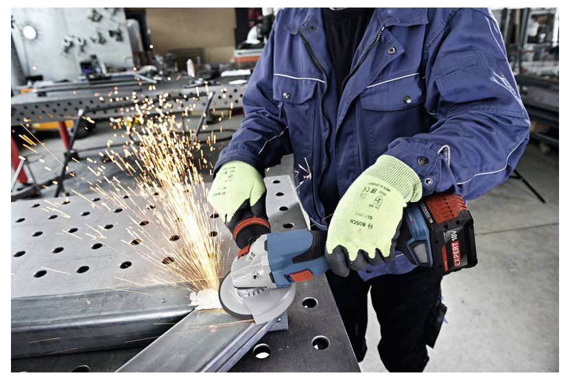 Eine Person in Sicherheitsausrüstung verwendet eine Winkelschleifer, um Metall auf einer Werkbank zu schneiden, wobei Funken an der Kontaktstelle sprühen.