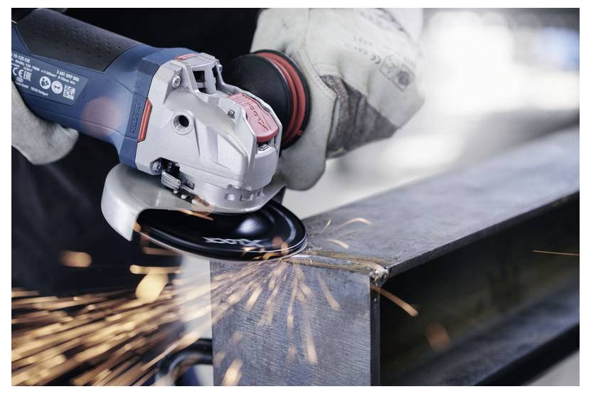 Ein Arbeiter verwendet eine Winkelschleifer, um einen Metallträger zu durchtrennen, wobei Funken an der Kontaktstelle sprühen.