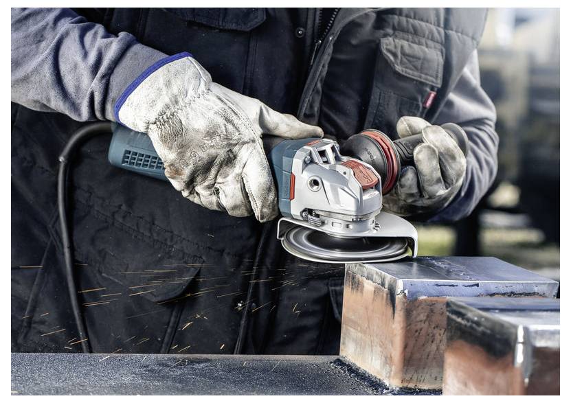 Eine Person mit Handschuhen verwendet eine Winkelschleifer, um die Kanten eines Metallstücks zu glätten, wobei sichtbare Funken von dem Werkzeug sprühen.