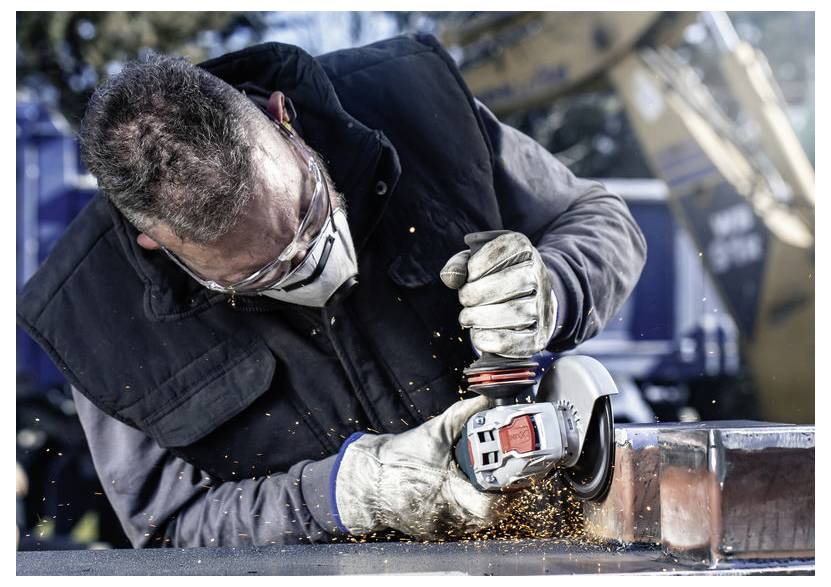 Ein Mann verwendet eine Trennschleifmaschine zum Schneiden von Metall und trägt Sicherheitsausrüstung, einschließlich Handschuhen, Schutzbrille und Maske. Funken sind sichtbar.