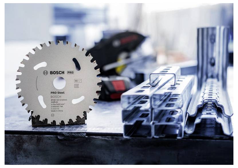 Kreissägeblatt zum Schneiden von Stahl, mit 'Pro Steel' markiert, auf einer Werkbank mit Metallträgern und einem unscharfen Hintergrund von Werkstattwerkzeugen.