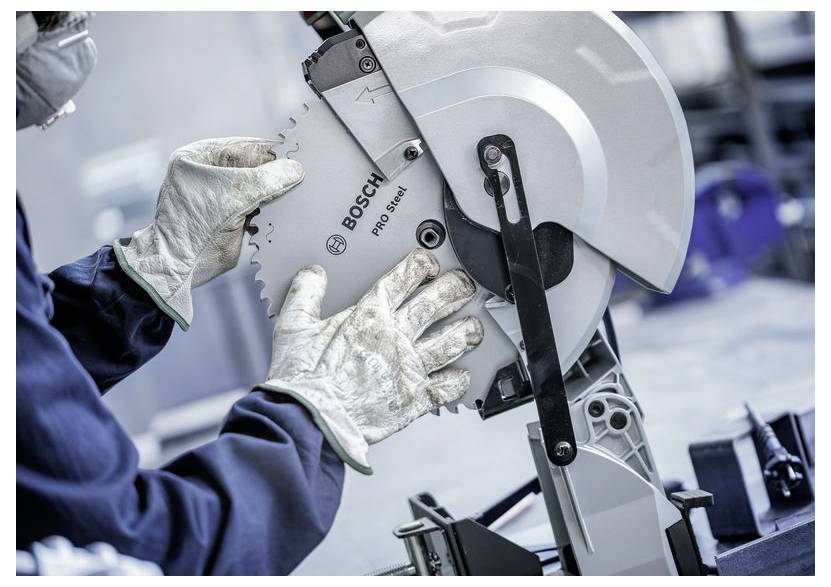Eine Person mit Handschuhen justiert eine Kreissägeblatt an einer Bosch Pro Select Schneidmaschine und betont dabei Sicherheit und Wartung der Ausrüstung.