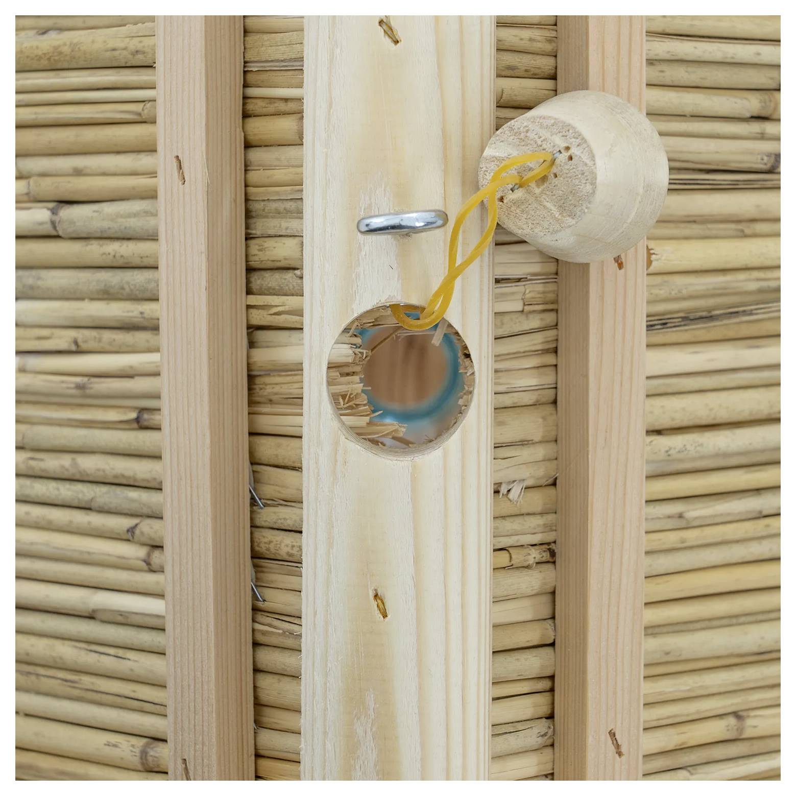 Nahaufnahme einer Wand aus Holz und Geflecht mit einem gelösten runden Stecker, der elektrische Verdrahtung zeigt.