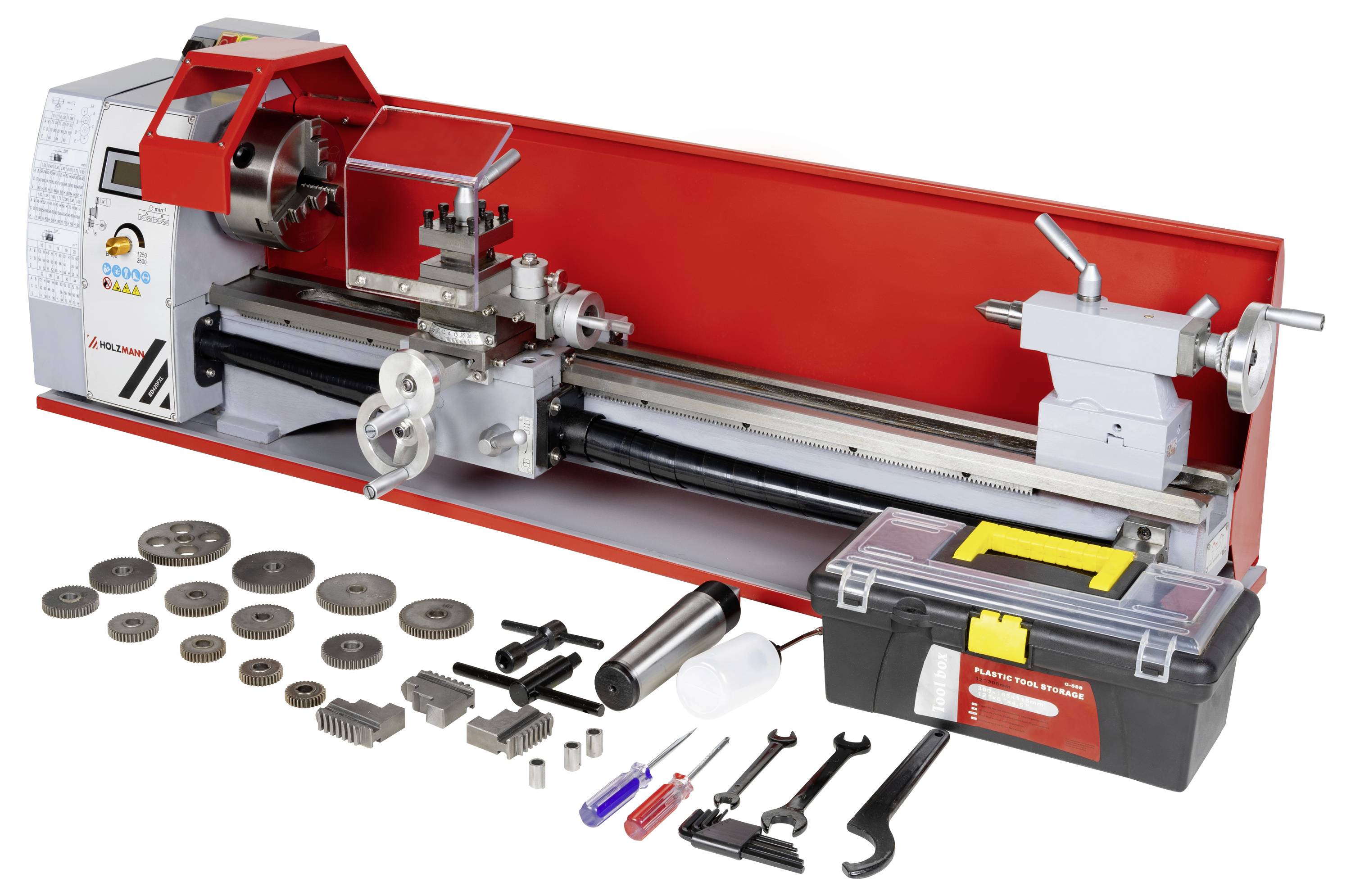 Eine Metallbohmaschine mit verschiedenen Werkzeugen und Komponenten, die davor angeordnet sind, einschließlich Schraubschlüssel, Zahnräder und einer Werkzeugkiste, für präzise Bearbeitung.